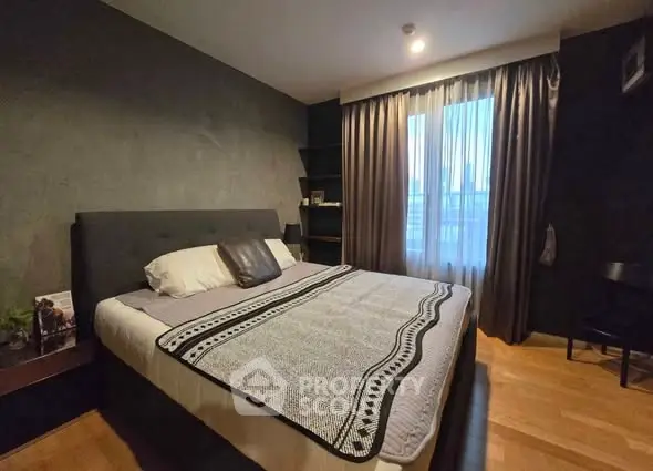 Cozy bedroom with modern decor and large window for natural light.