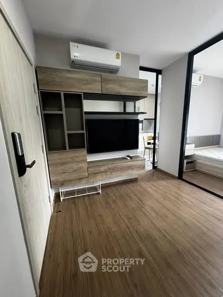 Modern living room with wooden flooring and built-in TV unit