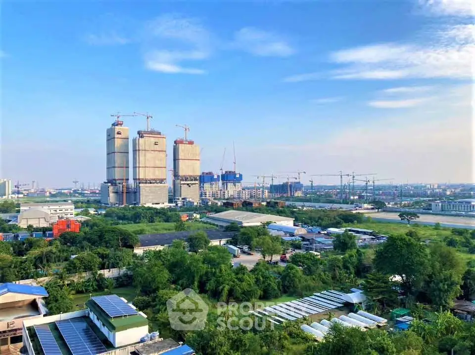 Stunning cityscape view with construction cranes and lush greenery, showcasing urban development potential.