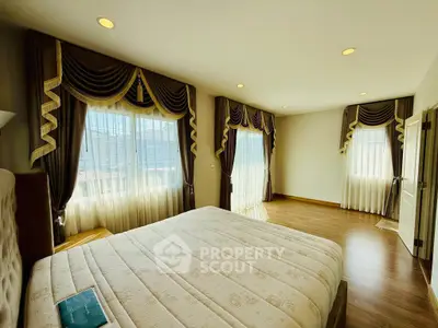 Spacious bedroom with elegant drapes and ample natural light