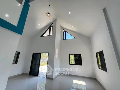 Spacious modern living room with high ceilings and large windows for natural light.