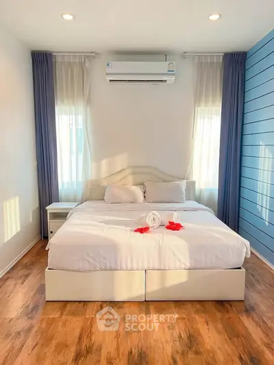 Cozy bedroom with elegant decor and natural light, featuring a comfortable bed and stylish wooden flooring.
