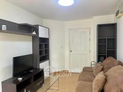 Cozy living room with modern furniture and TV, perfect for relaxation.