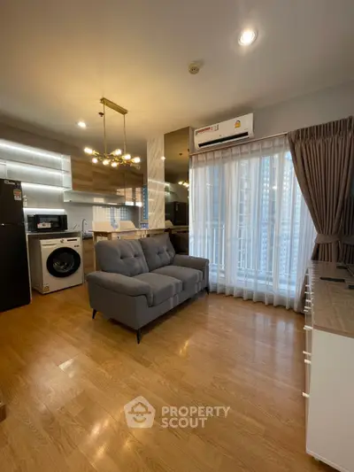 Modern living room with stylish decor, featuring a cozy sofa, washing machine, and elegant lighting.