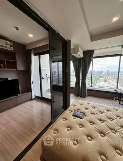 Luxurious bedroom with stunning city view and private balcony access in modern high-rise apartment.