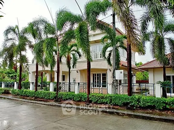 Stunning two-story house with lush palm trees and modern architecture in a serene neighborhood.