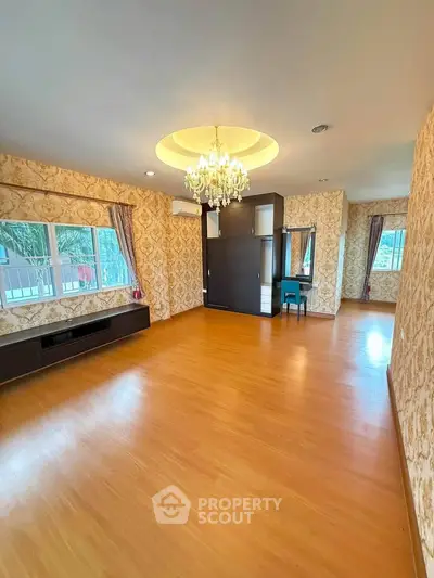 Spacious living room with elegant chandelier and wooden flooring