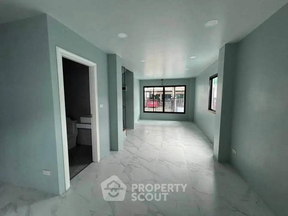 Spacious modern living room with large windows and elegant marble flooring