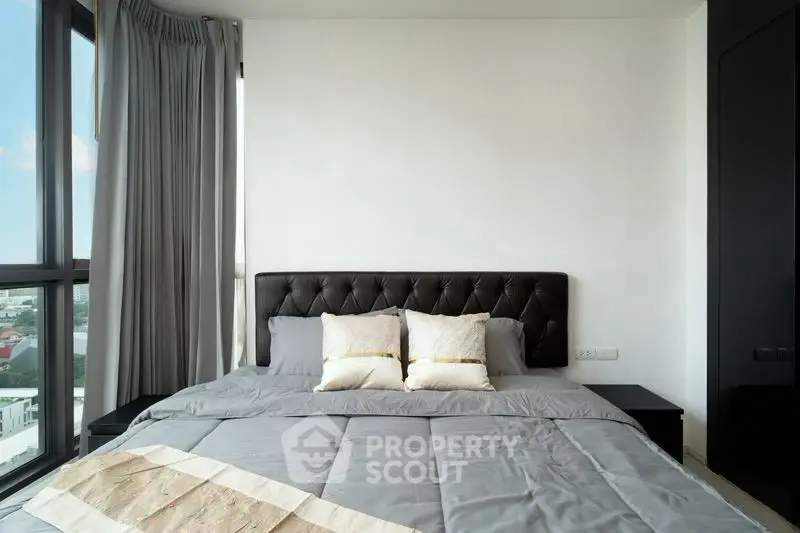 Modern bedroom with large windows and stylish decor in a high-rise apartment.