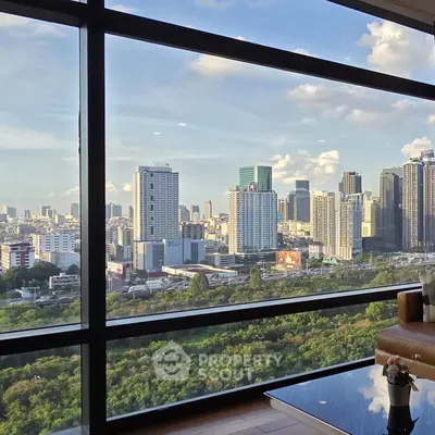 Stunning cityscape view from a modern high-rise apartment with floor-to-ceiling windows.