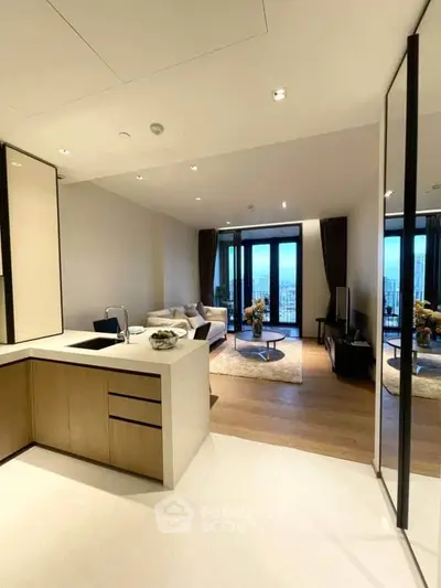 Modern open-layout living room with sleek kitchen and stunning city view.