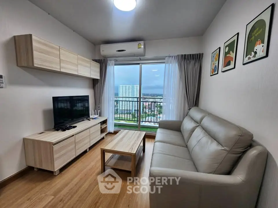 Modern living room with balcony view, stylish furniture, and wall art in a cozy apartment.