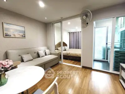 Modern living room with cozy bedroom view, featuring elegant decor and wooden flooring.
