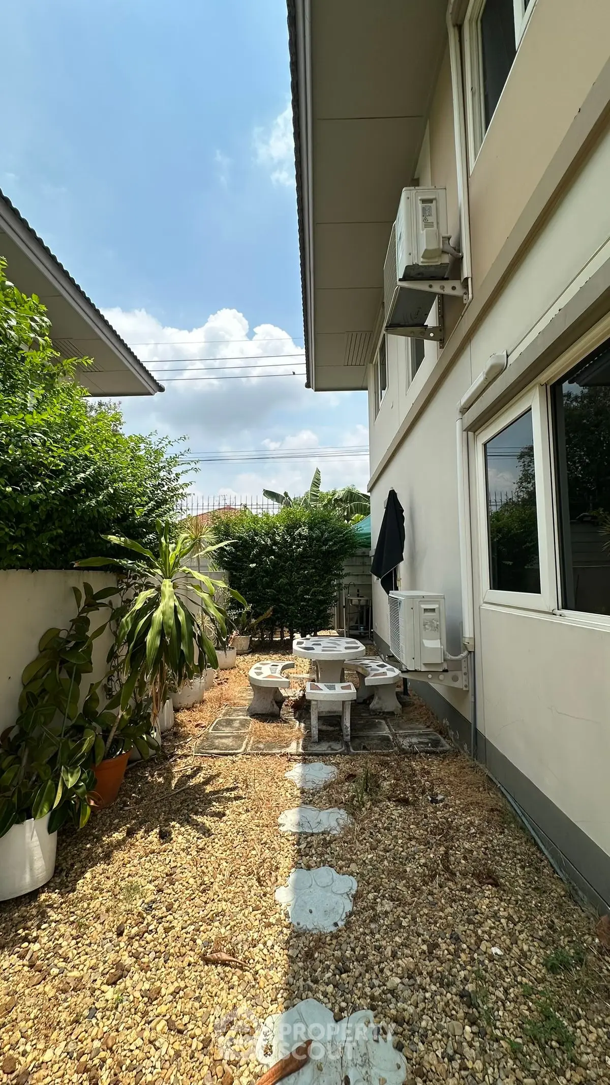 Charming backyard with stone path and outdoor seating, perfect for relaxation and entertaining.