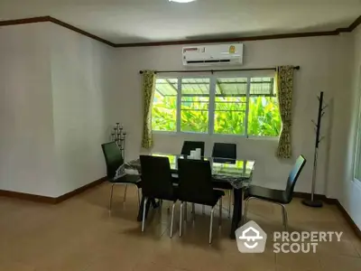 Spacious dining area with modern table and chairs, featuring large windows and air conditioning.