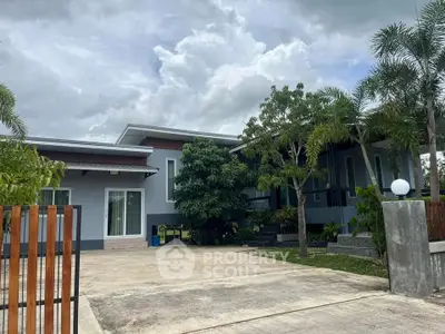 Modern single-story home with lush landscaping and spacious driveway