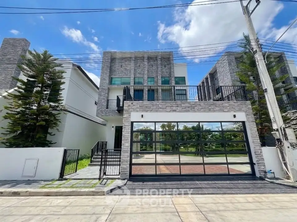 Modern two-story house with large glass garage door and stone facade
