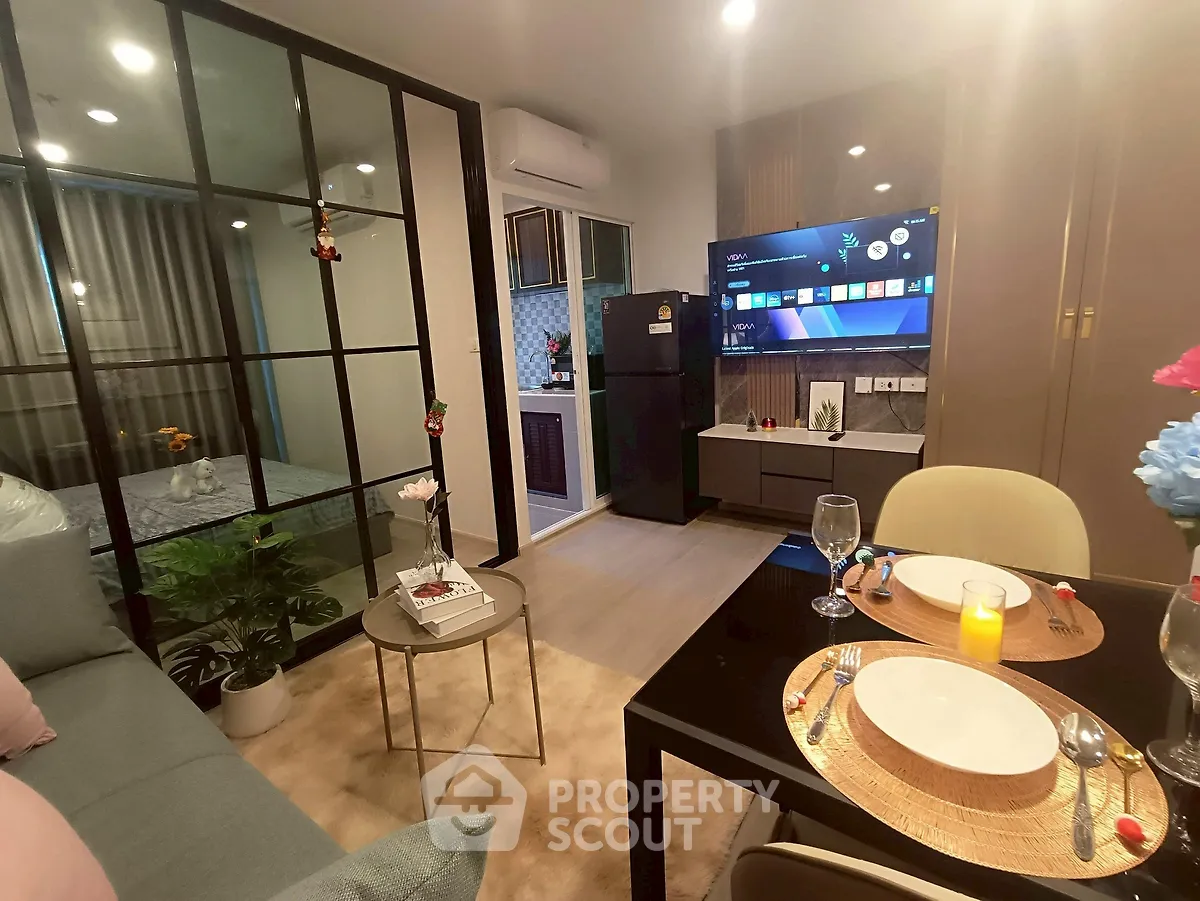 Modern living room with open kitchen and stylish decor in cozy apartment.
