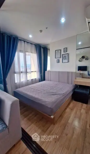 Cozy bedroom with modern decor and large windows in a stylish apartment.