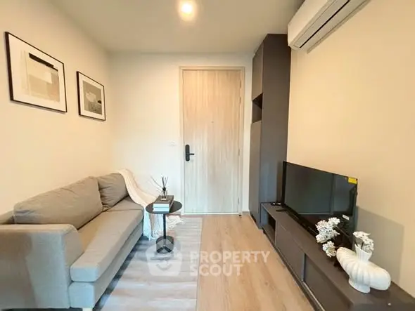 Cozy living room with modern decor and air conditioning, perfect for relaxation.