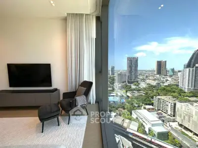 Luxurious living room with stunning city view through large window, modern furniture and sleek TV setup.