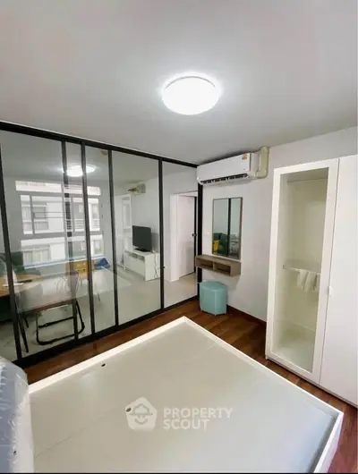 Modern bedroom with glass partition, air conditioning, and sleek design elements.