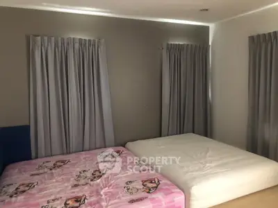 Cozy bedroom with two beds and elegant curtains, perfect for restful nights.
