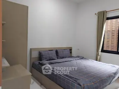 Cozy bedroom with modern decor and natural light, perfect for relaxation and comfort.