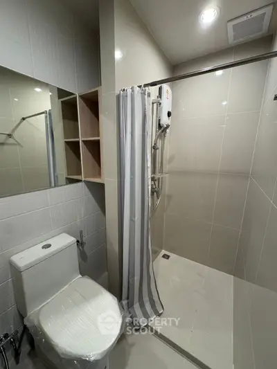 Modern bathroom with sleek shower and toilet in a contemporary apartment.