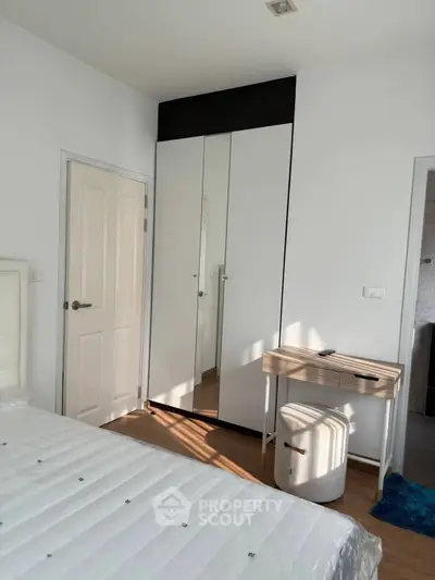 Bright bedroom with mirrored closet and cozy workspace
