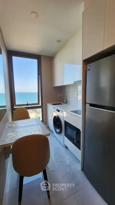 Modern kitchen with ocean view, sleek appliances, and dining area