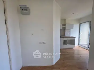 Spacious apartment interior with modern kitchen and wooden flooring, featuring a bright open layout.