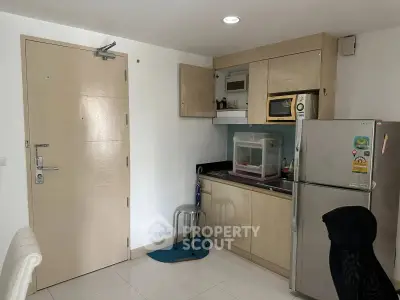 Compact kitchen with modern appliances and sleek cabinetry in a cozy apartment setting.