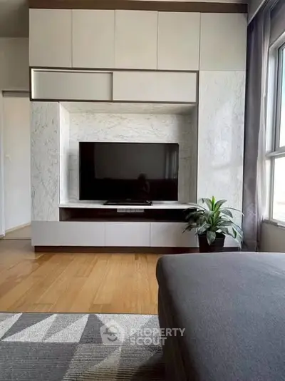 Modern living room with sleek TV unit and natural light