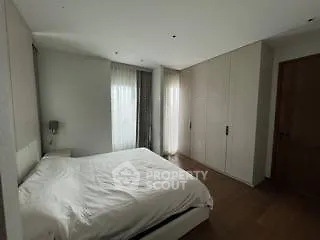 Spacious modern bedroom with sleek design and ample natural light.