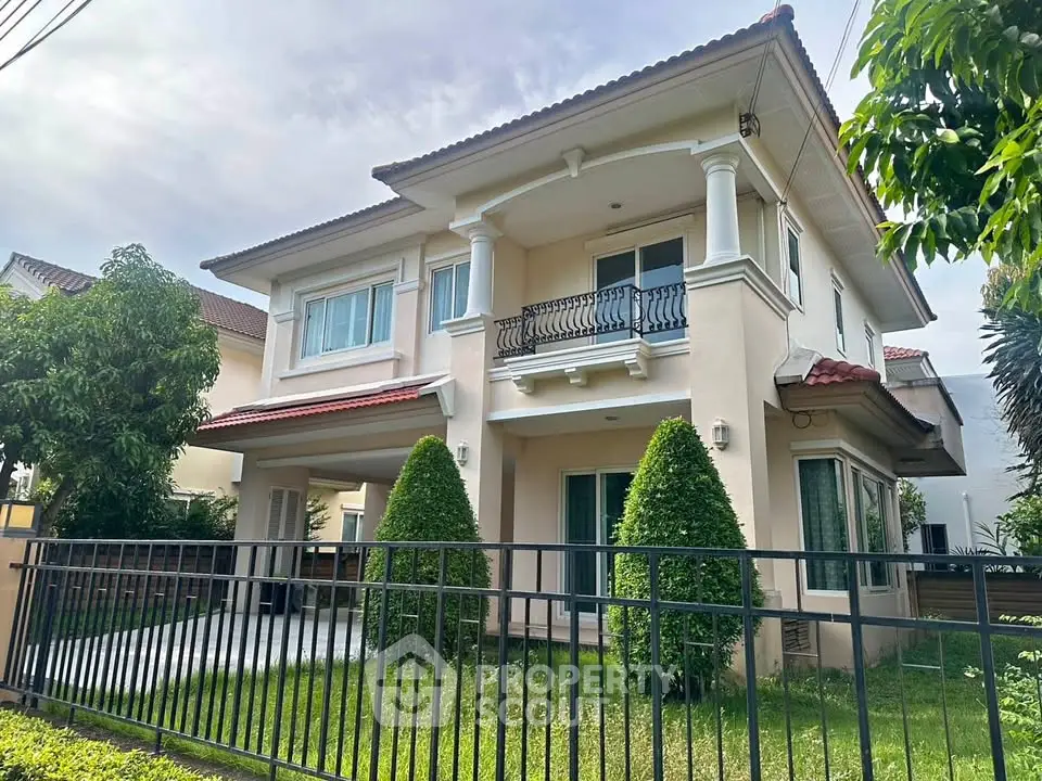 Charming two-story house with manicured garden and elegant balcony in a serene neighborhood.