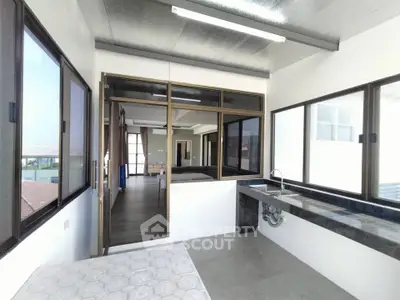 Spacious modern interior with large windows and sleek kitchen area, perfect for natural light lovers.
