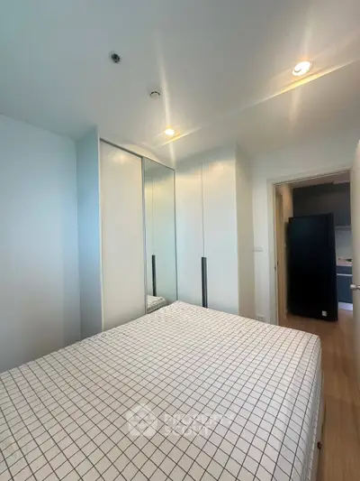 Modern bedroom with sleek wardrobe and cozy bed in a stylish apartment.