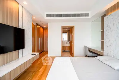 Modern bedroom with sleek design, featuring a wall-mounted TV and stylish wooden accents.