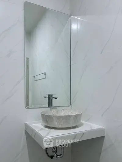 Modern minimalist bathroom with elegant marble sink and large mirror