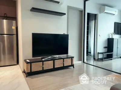 Modern living room with sleek TV stand and mirrored wardrobe in stylish apartment.