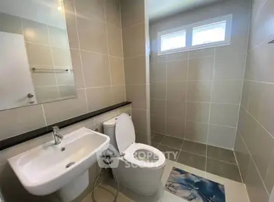 Modern bathroom with sleek fixtures and neutral tiles, featuring a spacious shower area.