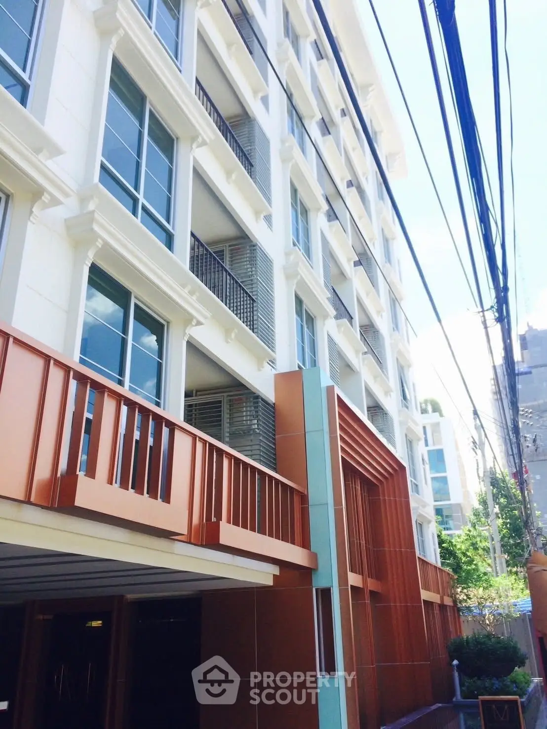 Modern multi-story residential building with sleek design and large windows.