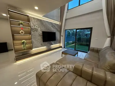 Luxurious modern living room with elegant decor and large windows offering garden views.