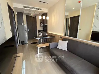 Modern living room with sleek kitchen and stylish sofa in open layout apartment.