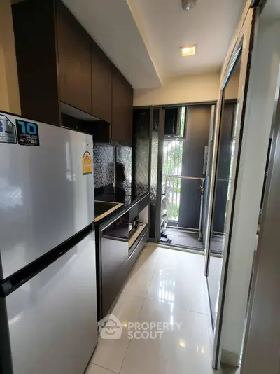 Modern compact kitchen with sleek appliances and balcony access