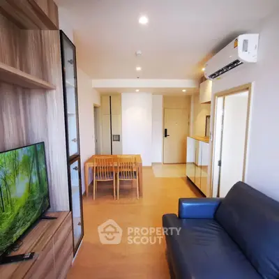 Modern living room with wooden flooring, sleek furniture, and air conditioning in a stylish apartment.