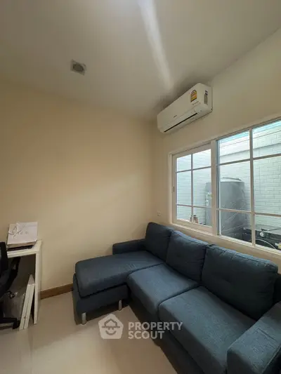Cozy living room with blue sectional sofa and air conditioning