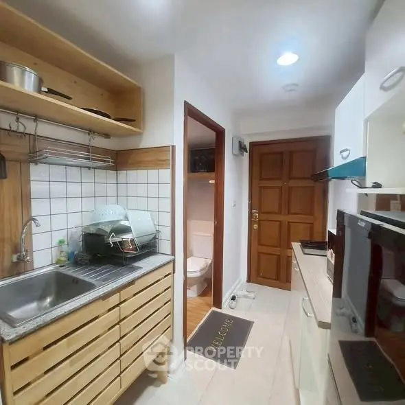 Cozy kitchen with wooden cabinets and modern appliances in compact layout.