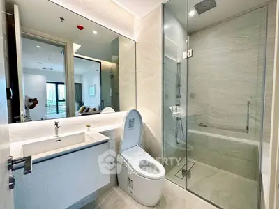 Modern bathroom with glass shower and sleek fixtures in luxury apartment.